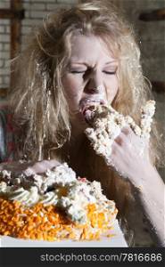 Young woman, ravaging a cake with both hands, eating uncontrollably
