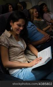 Young woman read book airplane night flight cabin leisure travel