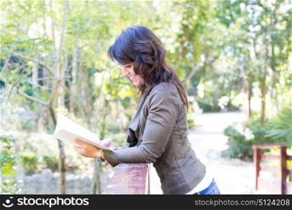 Young woman reading a book and relaxing at the park