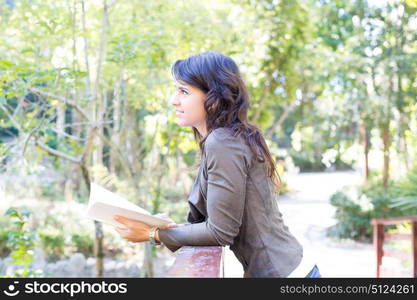 Young woman reading a book and relaxing at the park