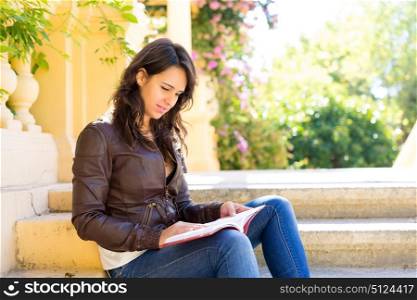 Young woman reading a book and relaxing at the park