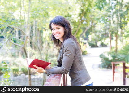 Young woman reading a book and relaxing at the park