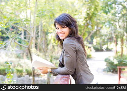 Young woman reading a book and relaxing at the park