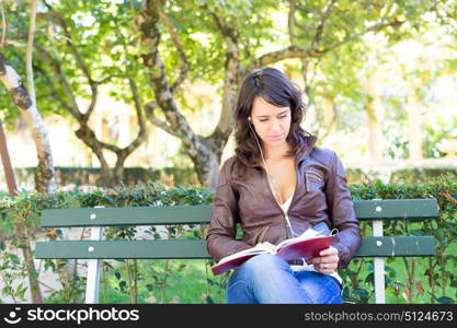 Young woman reading a book and relaxing at the park