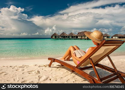 Young woman reading a book at beach. Young woman reading a book at the beach