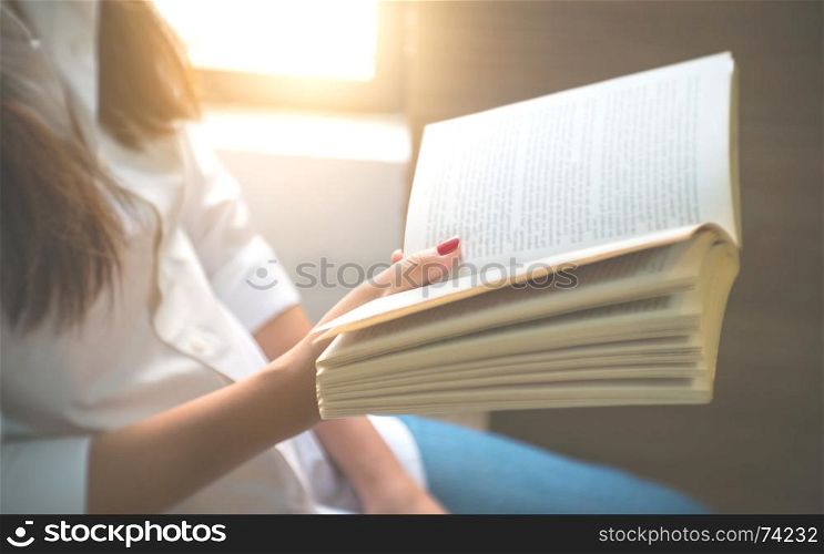 young woman reading a book at home.