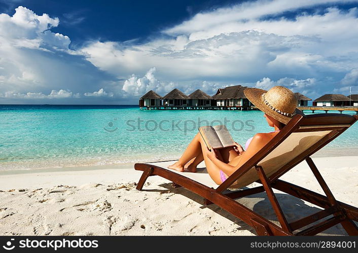 Young woman reading a book at the beach