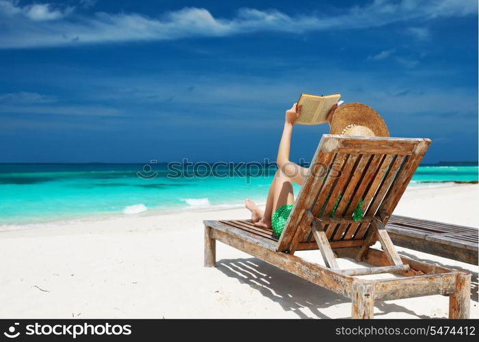 Young woman reading a book at the beach