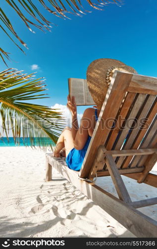 Young woman reading a book at the beach