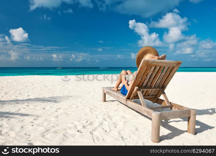 Young woman reading a book at the beach