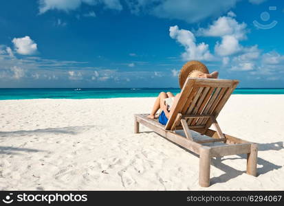 Young woman reading a book at the beach