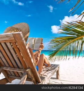 Young woman reading a book at the beach