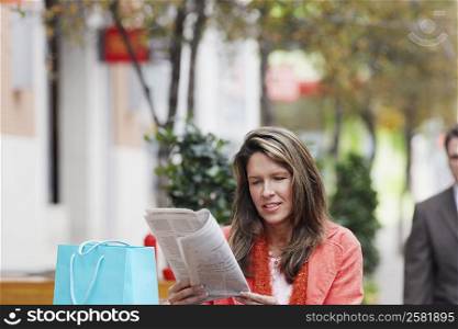 Young woman reading a newspaper