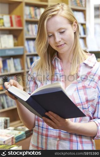 Young Woman Reading Book In Bookstore