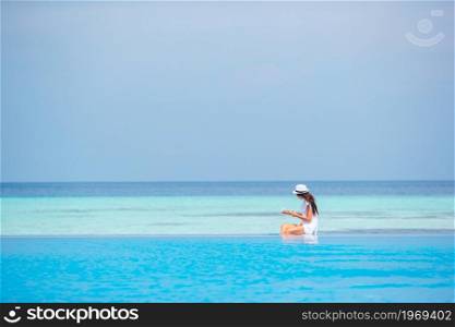 Young woman reading book on the beach and enjoy summer vacation. Young woman reading book during tropical white beach