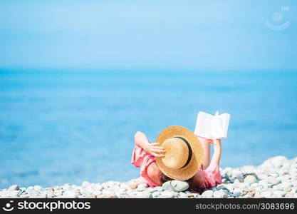 Young woman reading book on the beach. Young woman reading book during tropical white beach