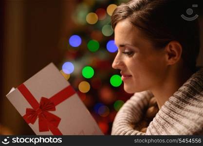 Young woman reading Christmas postcard