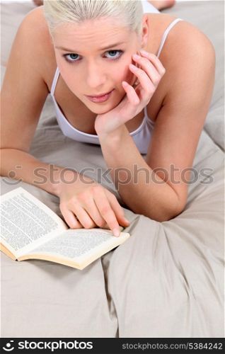young woman reading in bed