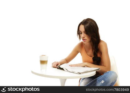 young woman reading newspaper at a table with latte macchiato coffee. young woman reading newspaper at a table with latte macchiato coffee on white background