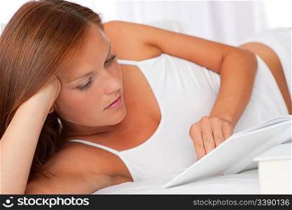 Young woman reading white book, shallow DOF