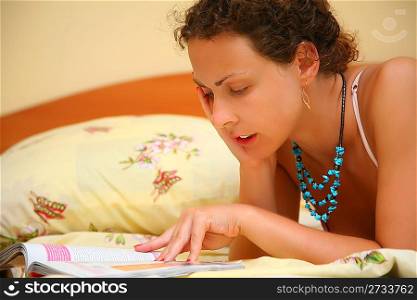 Young woman reads on bed