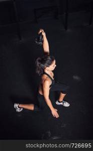 Young woman realizing indoor exercises with kettlebell