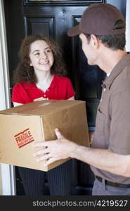 Young woman receives a home delivery from a courrier.