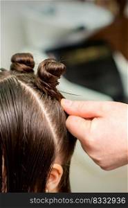 Young woman receives process of hairstyle by hairdresser at beauty hair salon. Young woman receives process of hairstyle