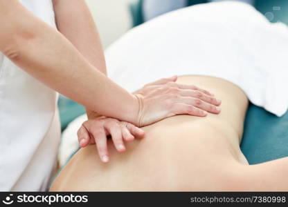 Young woman receiving a back massage by professional therapist. Female patient is receiving treatment in a spa center. . Young woman receiving a back massage by professional therapist.