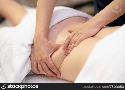 Young woman receiving a back massage in a physiotherapy center. Female patient is receiving treatment by professional therapist.. Young woman receiving a back massage in a physiotherapy center