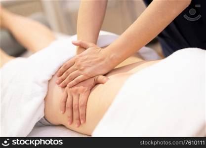 Young woman receiving a back massage in a physiotherapy center. Female patient is receiving treatment by professional therapist.. Young woman receiving a back massage in a physiotherapy center