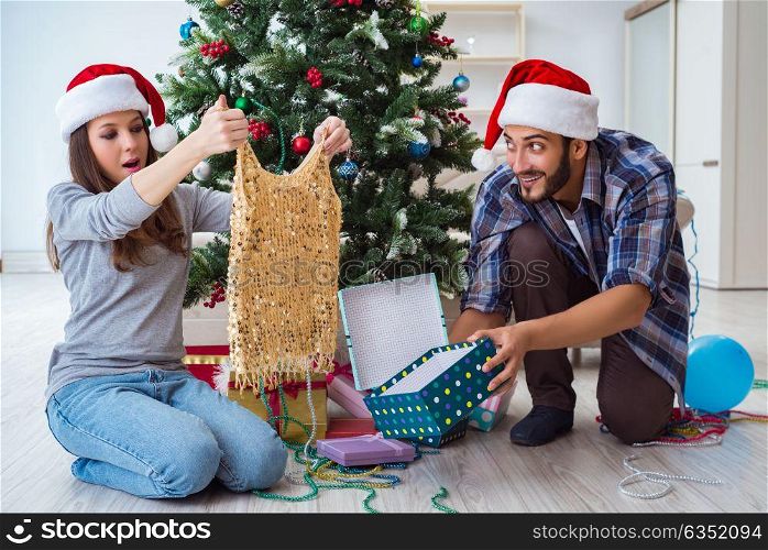 Young woman receiving dress as christmas gift