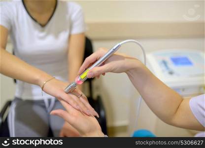 Young woman receiving laser therapy on wrist hand