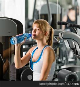Young woman relax at the gym sitting on fitness machine