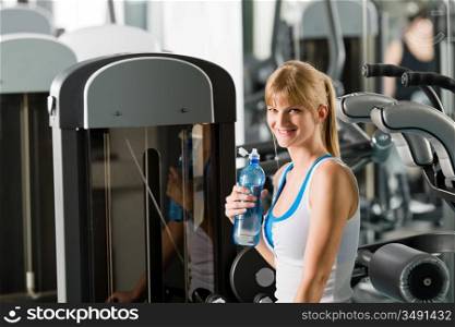 Young woman relax at the gym sitting on fitness machine