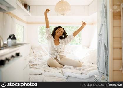 Young woman relax in bedroom, camping in a trailer. Couple travels on van, romantic vacations on motorhome, camper leisures in camping-car. Young woman relax in bedroom, camping in a traile