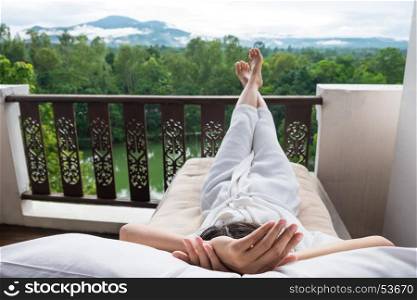 Young woman relax on bed and enjoying mountain view.