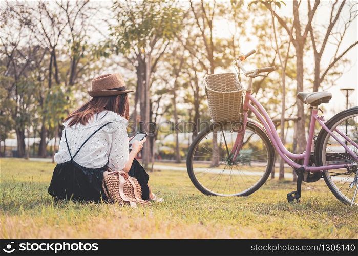 Young woman relaxing and using smart phone and surf internet in the park