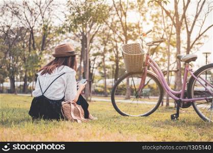 Young woman relaxing and using smart phone and surf internet in the park