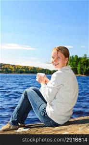 Young woman relaxing at lake shore