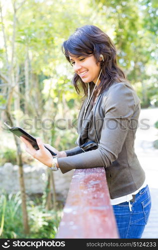 Young woman relaxing at the park with a tablet computer