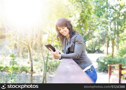 Young woman relaxing at the park with a tablet computer