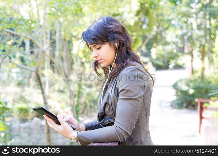 Young woman relaxing at the park with a tablet computer