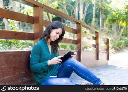 Young woman relaxing at the park with a tablet computer