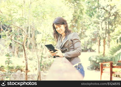 Young woman relaxing at the park with a tablet computer