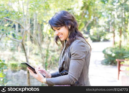 Young woman relaxing at the park with a tablet computer