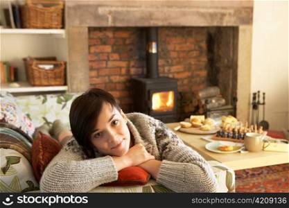 Young woman relaxing by fire
