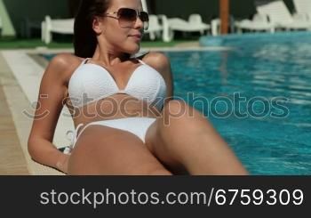 Young Woman Relaxing by the Pool, Looking at Camera