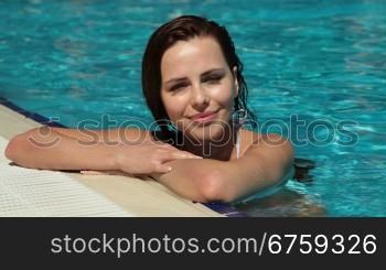 Young Woman Relaxing In Swimming Pool, Looking at Camera