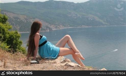 young woman relaxing in the mountains by the sea